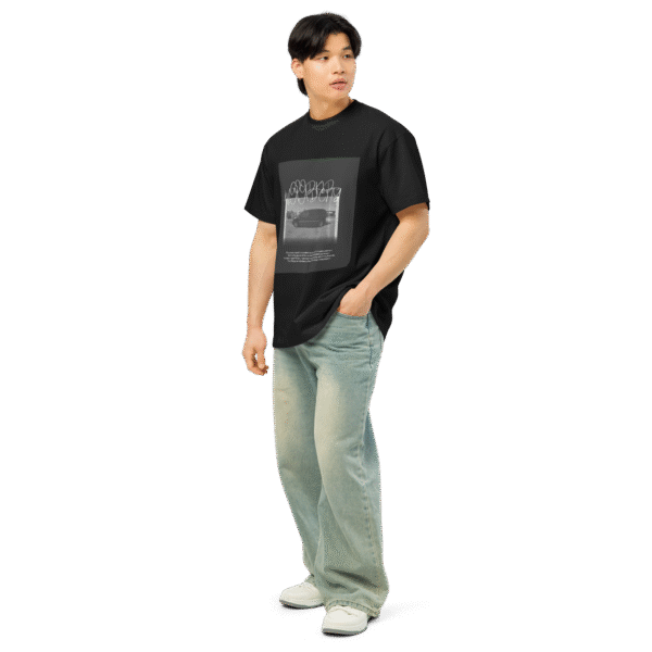Left-front angled view of a black men’s box-fit t-shirt with a structured silhouette and classic crew neckline. Displayed against a neutral background, the shirt’s deep tone and clean lines reflect the bold, minimalist aesthetic of the “Good Kid Maad City” collection—channeling lyrical grit and urban fashion into a confident, wearable statement.