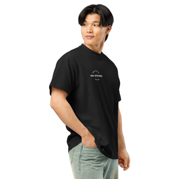 Right-front angled view of a men’s box-fit t-shirt in solid black, featuring a structured silhouette, relaxed sleeves, and classic crew neckline. Set against a neutral background, the shirt’s clean lines and deep tone reflect Rap Stitches’ music-inspired streetwear—fusing everyday comfort with bold, minimalist style.