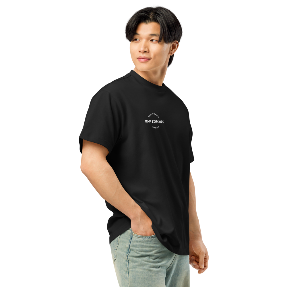 Right-front angled view of a men’s box-fit t-shirt in solid black, featuring a structured silhouette, relaxed sleeves, and classic crew neckline. Set against a neutral background, the shirt’s clean lines and deep tone reflect Rap Stitches’ music-inspired streetwear—fusing everyday comfort with bold, minimalist style.